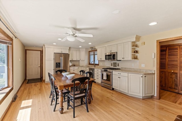 kitchen featuring a ceiling fan, open shelves, white cabinets, light wood finished floors, and stainless steel appliances