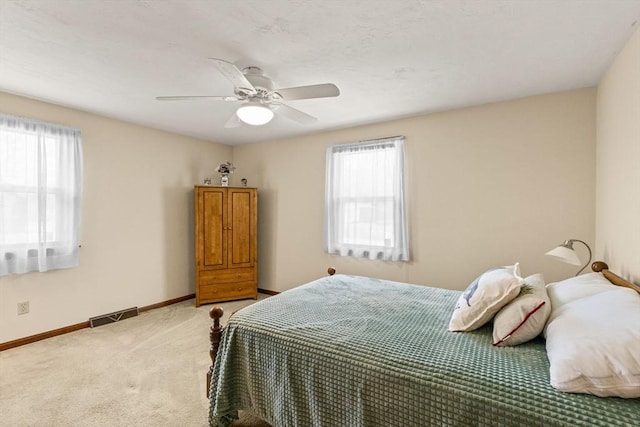 bedroom featuring light colored carpet, baseboards, visible vents, and a ceiling fan