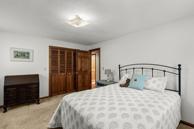 carpeted bedroom featuring a closet and baseboards