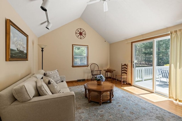 living room with ceiling fan, vaulted ceiling, and wood finished floors