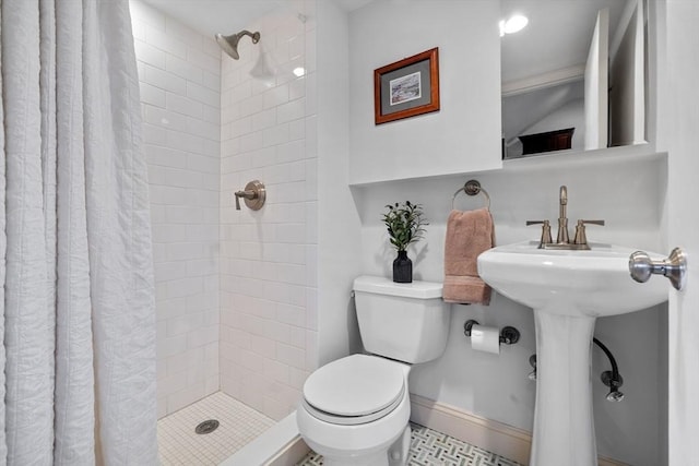 bathroom with a shower stall, baseboards, and toilet