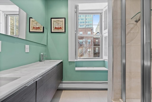 bathroom with a sink, double vanity, a baseboard heating unit, and a stall shower