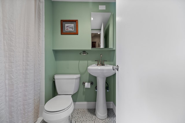 bathroom featuring toilet and a shower with shower curtain