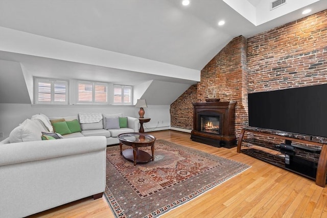 living area featuring wood finished floors, visible vents, and lofted ceiling