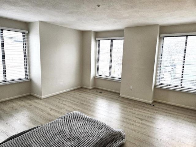 unfurnished bedroom featuring a textured ceiling and light wood-type flooring