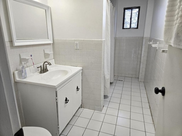 bathroom featuring tile walls, vanity, toilet, and tile patterned floors