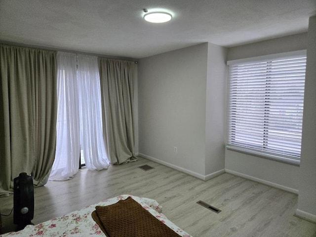 unfurnished room with a healthy amount of sunlight and light hardwood / wood-style floors