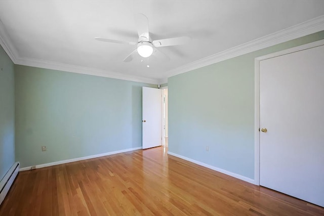 spare room featuring crown molding, ceiling fan, baseboards, wood finished floors, and a baseboard radiator