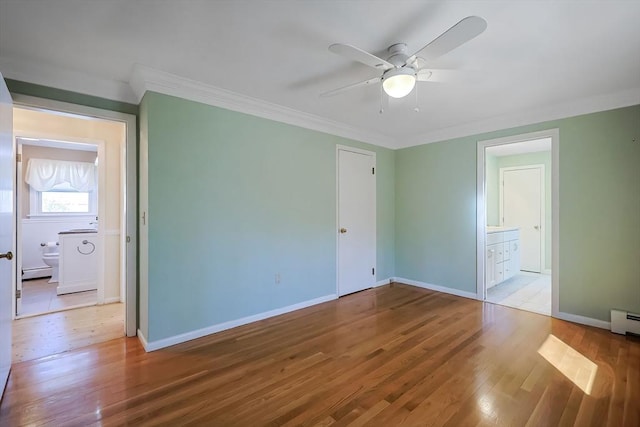 unfurnished bedroom featuring ornamental molding, wood finished floors, connected bathroom, baseboards, and baseboard heating