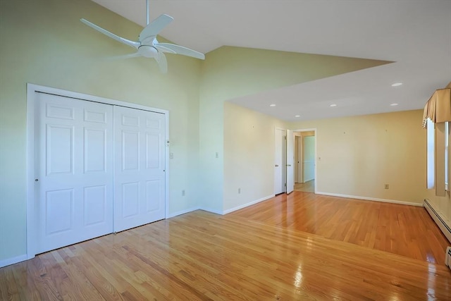 spare room with baseboards, light wood-style floors, and vaulted ceiling