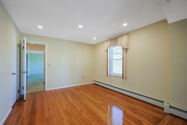 empty room featuring baseboards, recessed lighting, light wood-type flooring, and a baseboard radiator