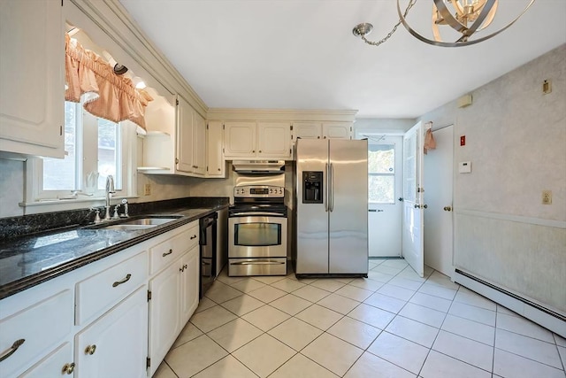 kitchen with a baseboard heating unit, under cabinet range hood, plenty of natural light, stainless steel appliances, and a sink