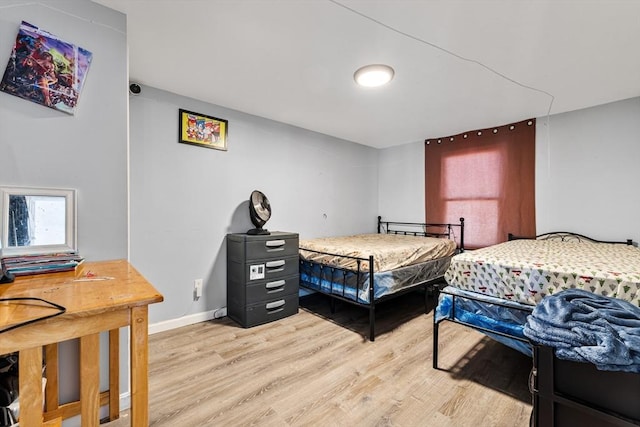 bedroom featuring baseboards and light wood-style floors