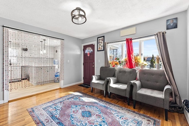 foyer with a textured ceiling, baseboards, and wood finished floors