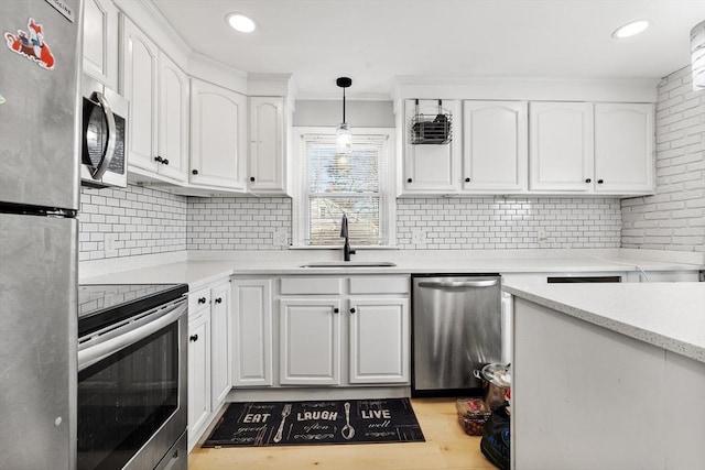 kitchen featuring decorative backsplash, white cabinets, stainless steel appliances, and a sink