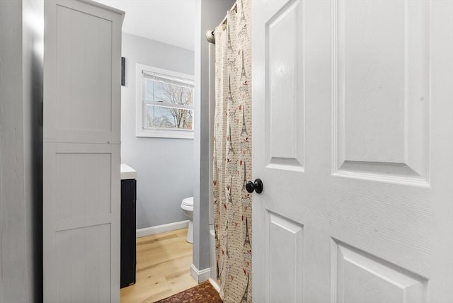 full bath with curtained shower, baseboards, toilet, wood finished floors, and vanity