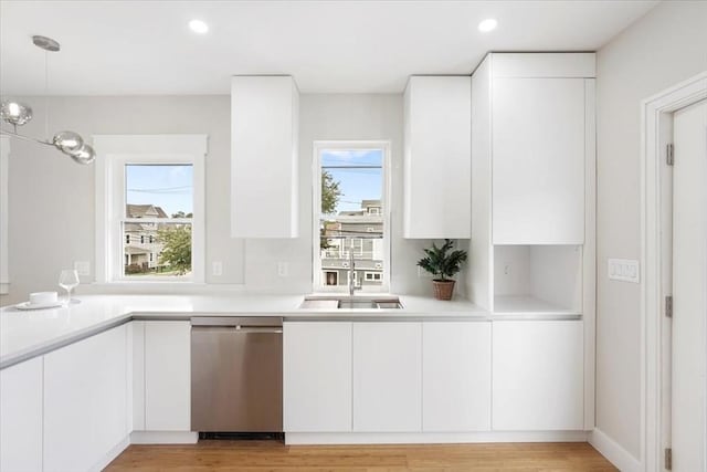 kitchen with sink, pendant lighting, white cabinets, and dishwasher