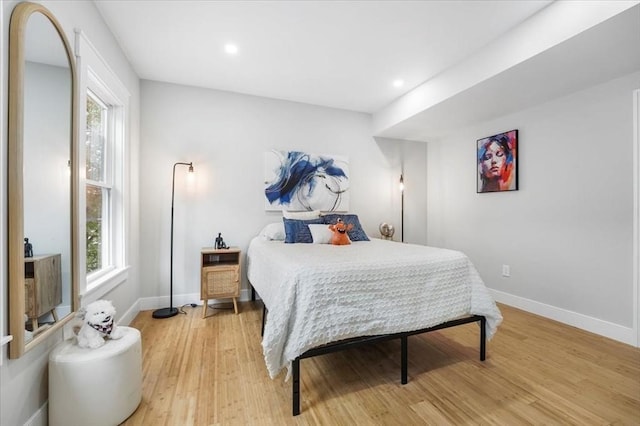 bedroom with hardwood / wood-style flooring and multiple windows