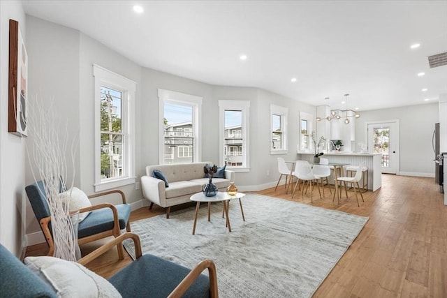 living room with light hardwood / wood-style flooring and a healthy amount of sunlight