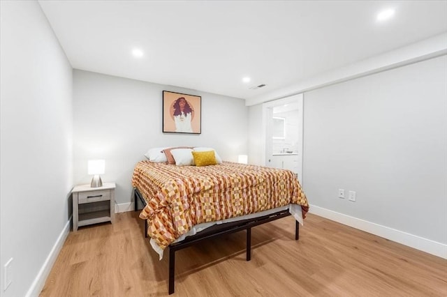 bedroom featuring light hardwood / wood-style floors and ensuite bathroom