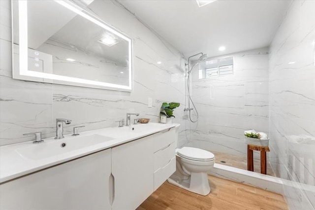 bathroom featuring tile walls, toilet, vanity, and tiled shower