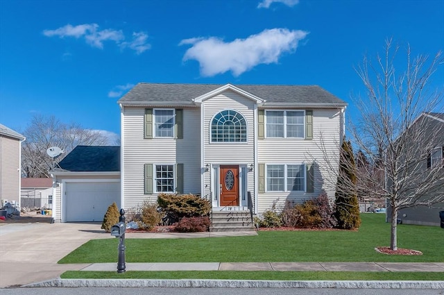 colonial house with driveway, a front lawn, and an attached garage