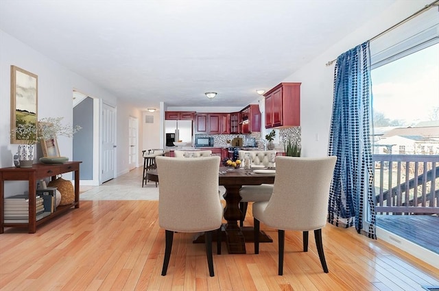 dining space featuring light wood finished floors and baseboards