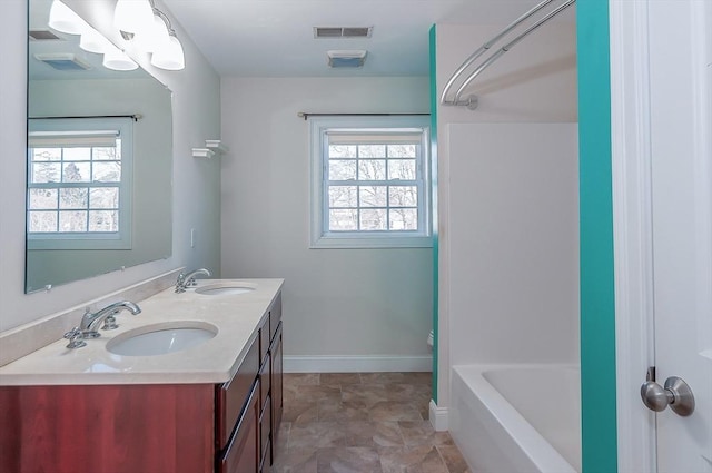 bathroom featuring double vanity, baseboards, visible vents, and a sink