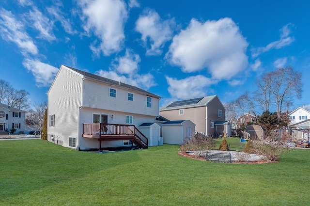 rear view of property with a storage shed, a wooden deck, a lawn, and an outdoor structure