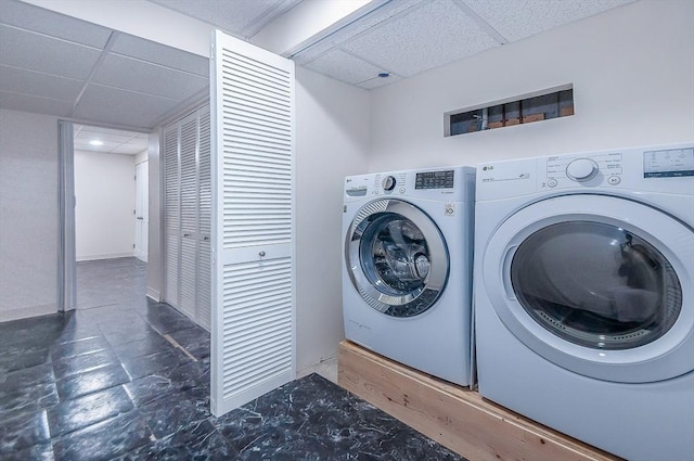 washroom featuring laundry area, washer and clothes dryer, and baseboards