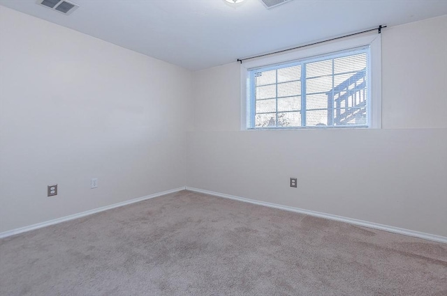 spare room featuring carpet flooring, visible vents, and baseboards