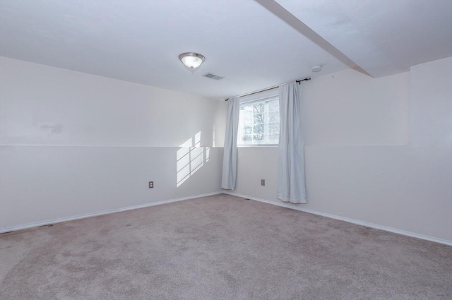 carpeted spare room featuring visible vents and baseboards