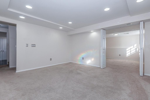 basement featuring recessed lighting, baseboards, and light colored carpet