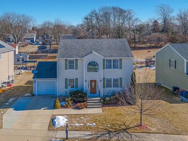 view of front of home featuring driveway, a shingled roof, and an attached garage