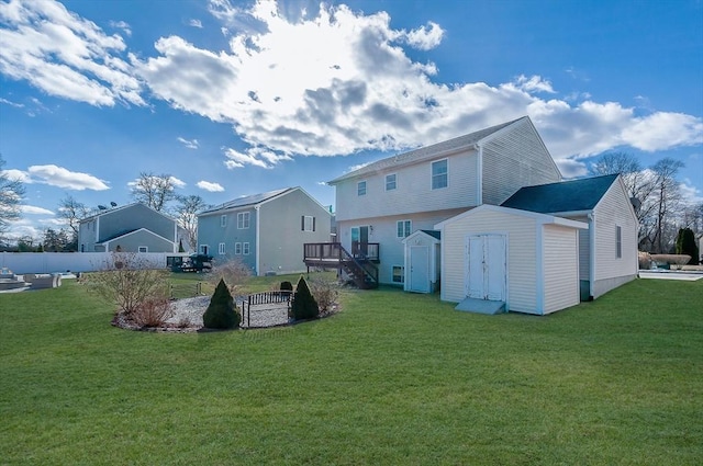 back of house with an outbuilding, a yard, and a storage unit