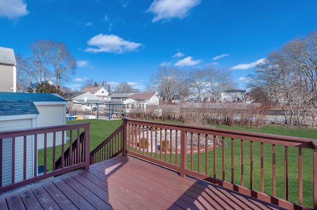 wooden deck featuring a residential view, a lawn, and fence