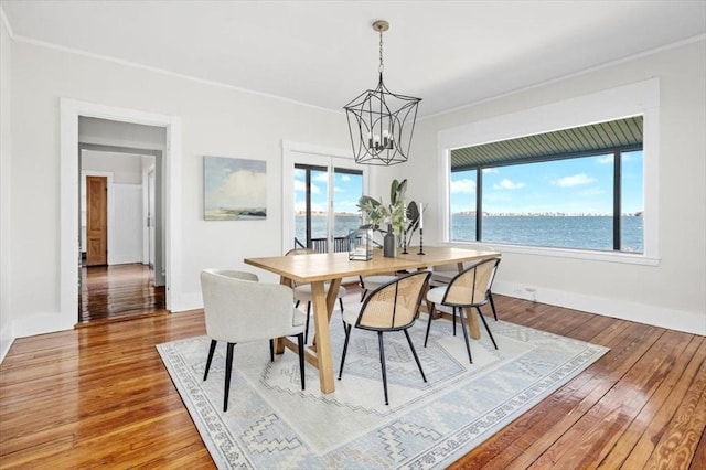 dining area with a healthy amount of sunlight, crown molding, and hardwood / wood-style flooring