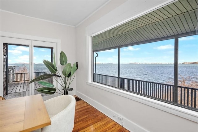 office space featuring a water view, crown molding, baseboards, and wood finished floors