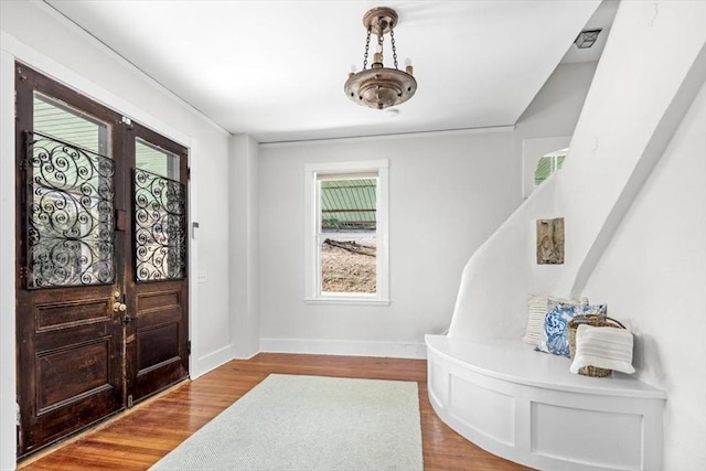 foyer featuring baseboards and wood finished floors