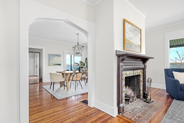 interior space featuring visible vents, hardwood / wood-style flooring, an inviting chandelier, crown molding, and baseboards