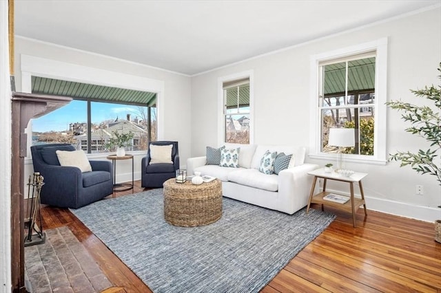 living area with crown molding, baseboards, and hardwood / wood-style flooring