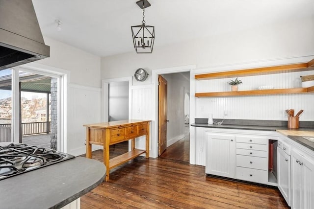 kitchen with dark countertops, dark wood finished floors, decorative light fixtures, white cabinetry, and open shelves