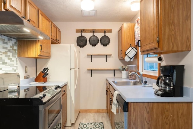 kitchen featuring light hardwood / wood-style floors, sink, backsplash, and stainless steel appliances