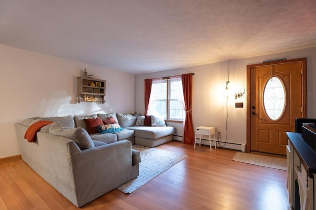 living room with baseboard heating and light hardwood / wood-style flooring