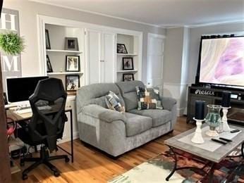 interior space with crown molding, hardwood / wood-style flooring, and built in shelves