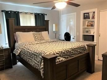 bedroom with ceiling fan and light carpet