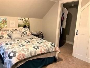 bedroom with light carpet and lofted ceiling