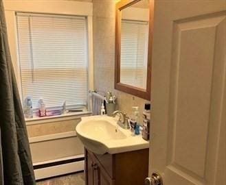 bathroom featuring baseboard heating and vanity