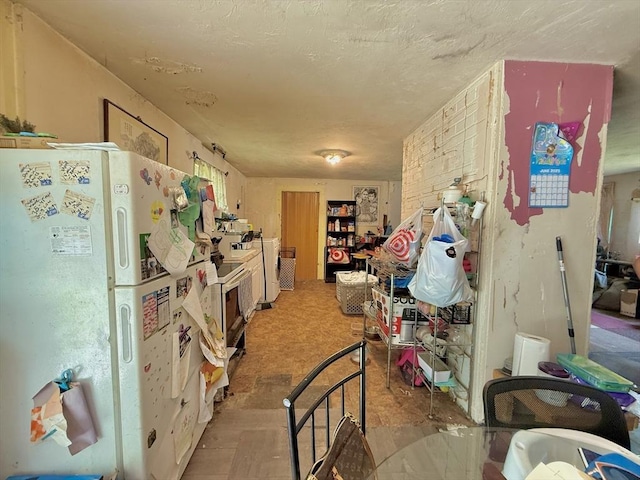 46 Barry Rd, Worcester, MA 01609 - kitchen with freestanding refrigerator, washer / dryer, and a textured ceiling