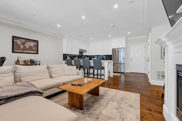 living room featuring crown molding and dark hardwood / wood-style flooring